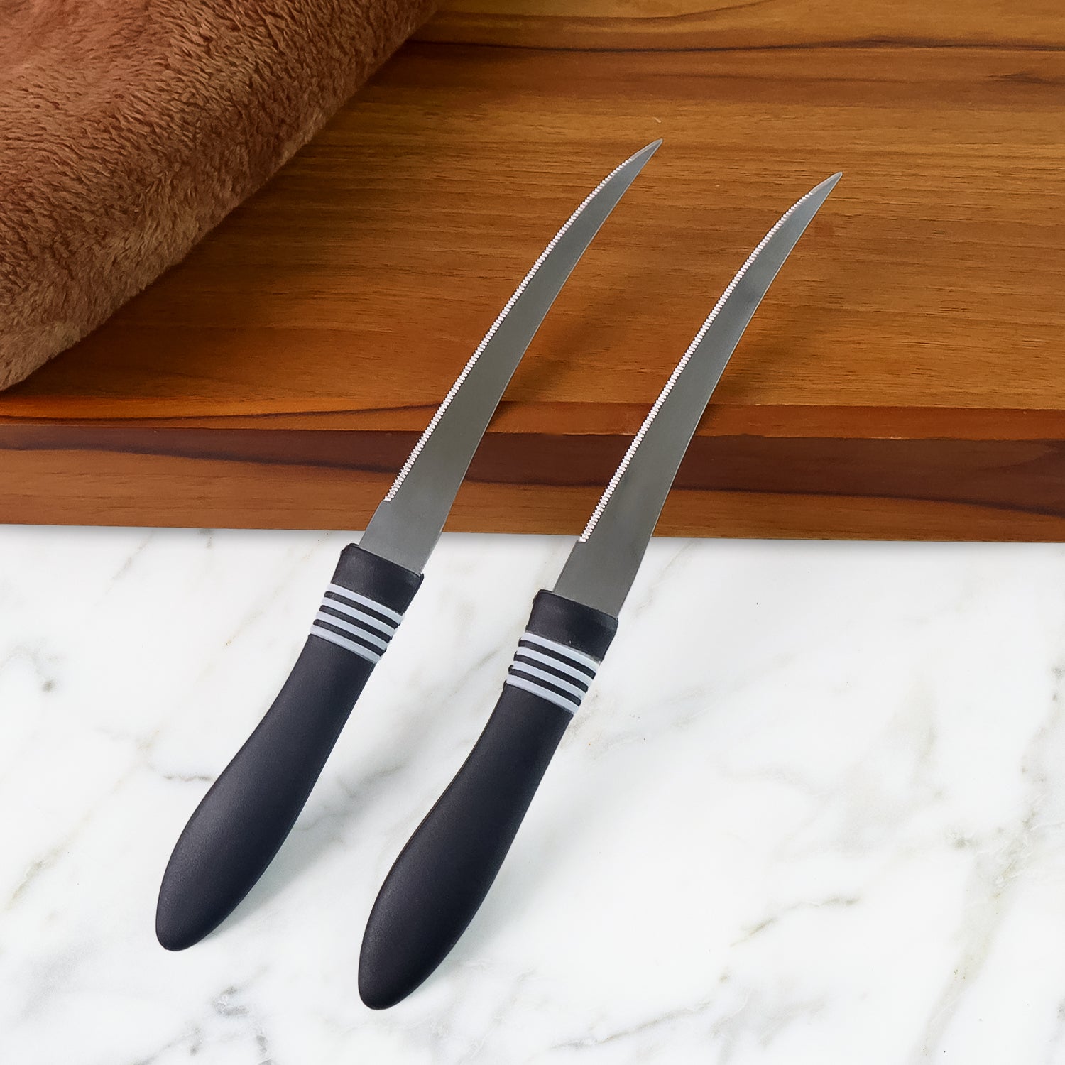 Serrated kitchen knife set with curved stainless steel blades on display