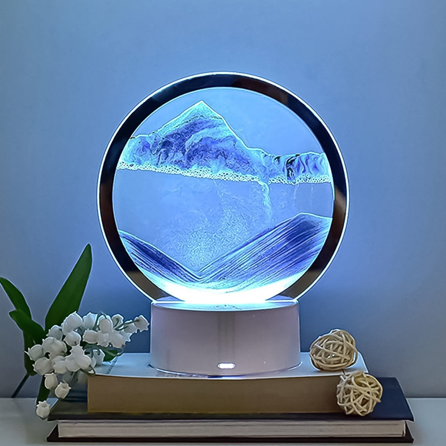 Elegant Moving Sand Art Picture with 5-color light feature in a round glass frame.
