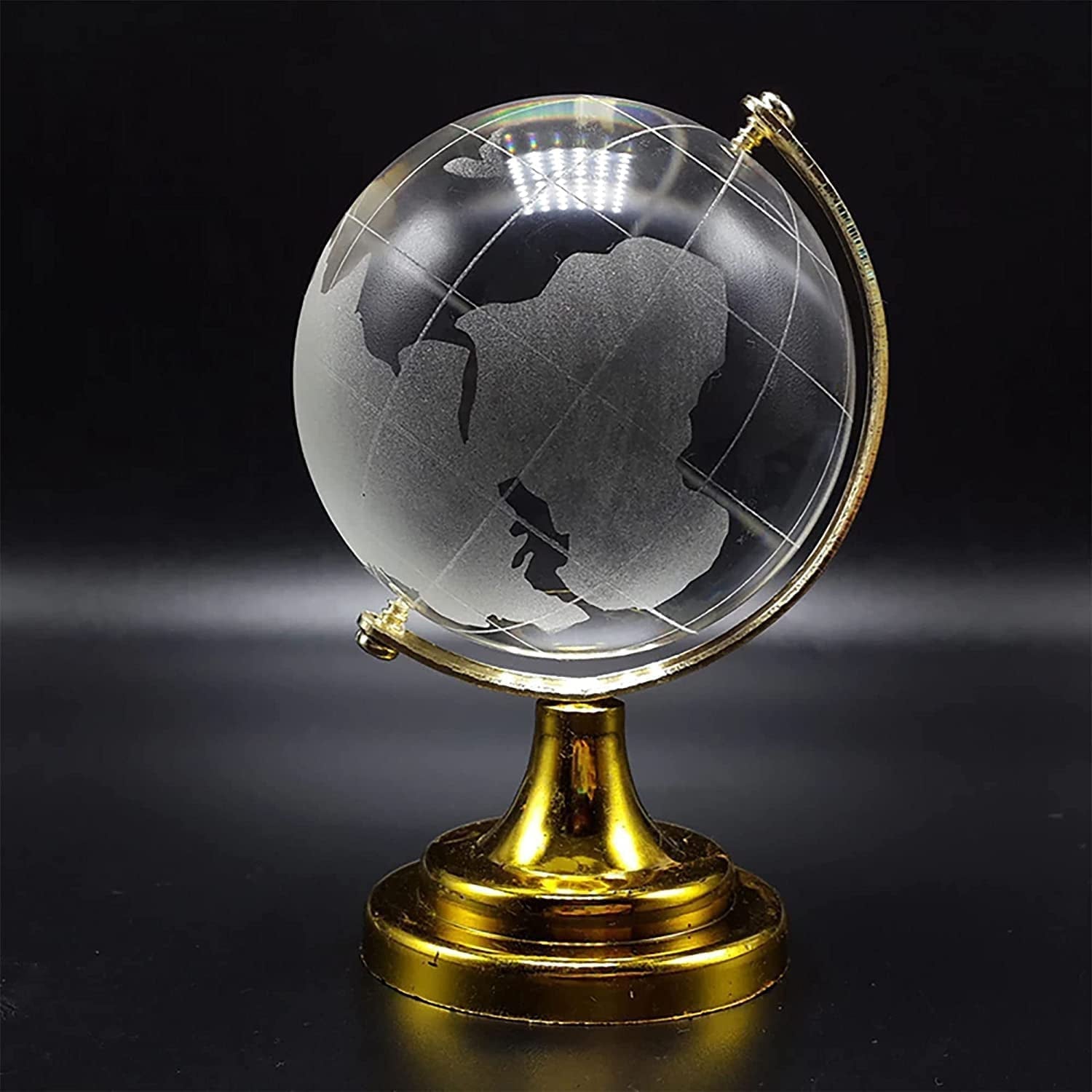 Crystal World Globe (50mm) with golden stand on a wooden surface.