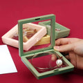 Floating Jewelry Display Box with a silver necklace and ring inside.