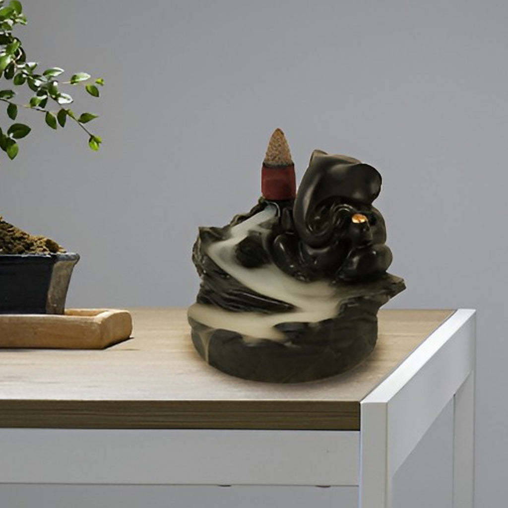 Backflow Incense Burner stand featuring Lord Ganesha, creating a cascading smoke effect.