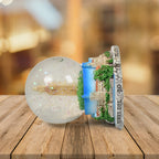 Decorative snow globe illuminating a desk, creating a cozy ambiance.