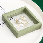 Side view of a clear Floating Jewelry Display Box with an item inside.