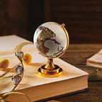 Crystal World Globe with golden stand, placed on a table as a sophisticated office decor item.