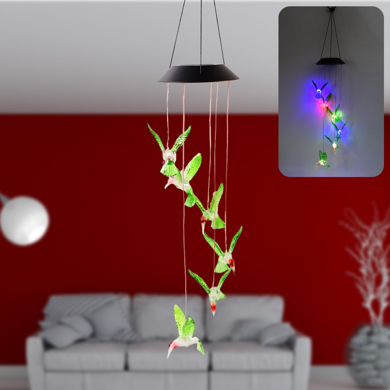 Solar hummingbird wind chime illuminated with colorful LED lights in garden