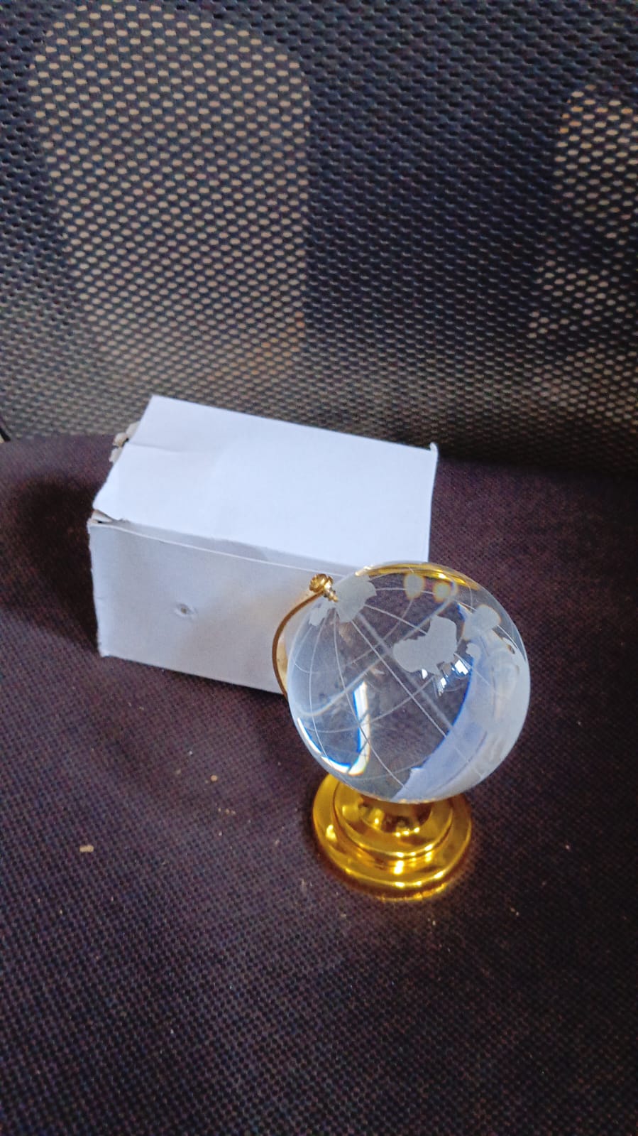 Hand holding the compact Crystal World Globe, illustrating its portable size and crystal clarity.